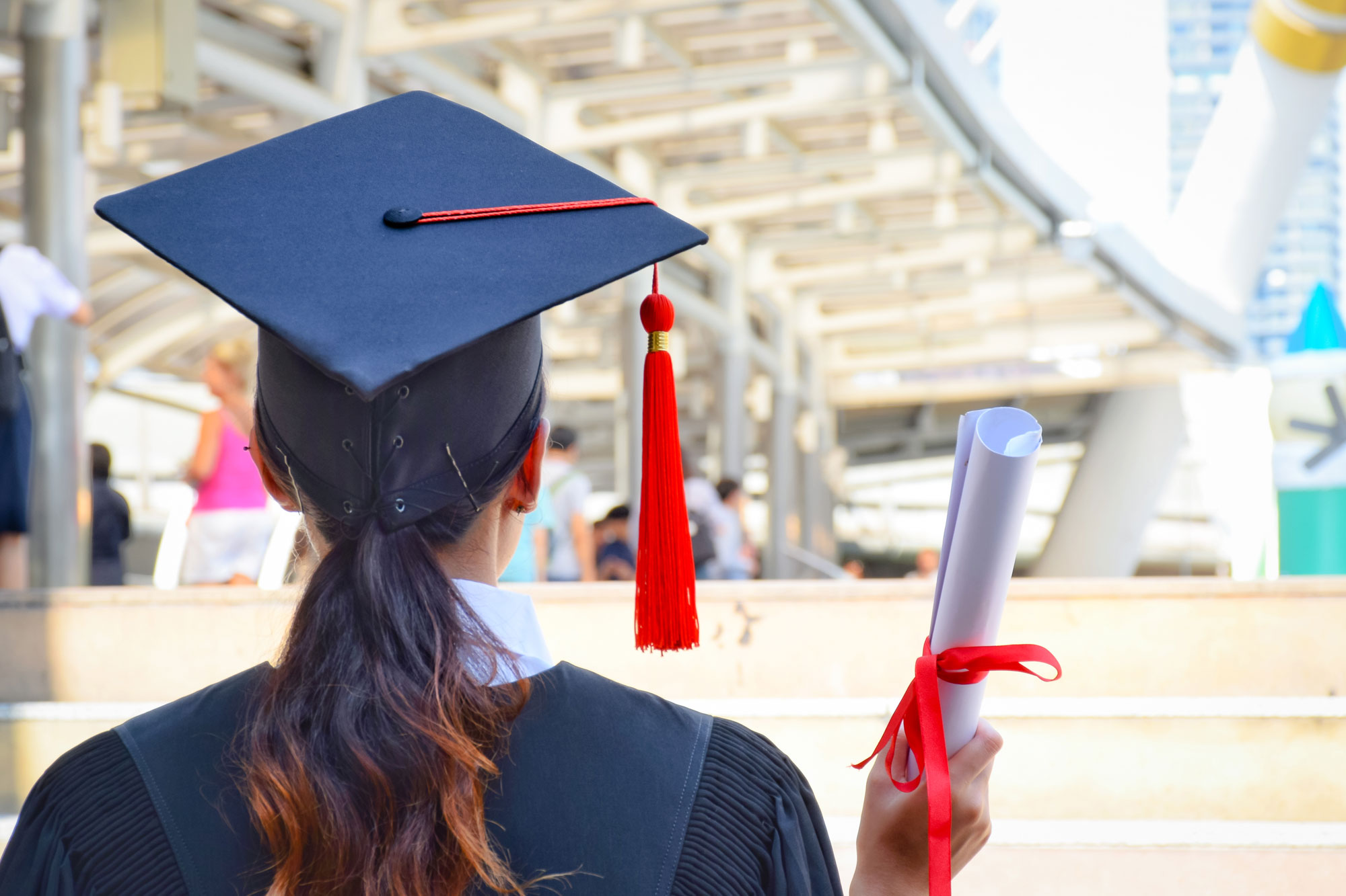 A diploma graduate working adult with graduation attire